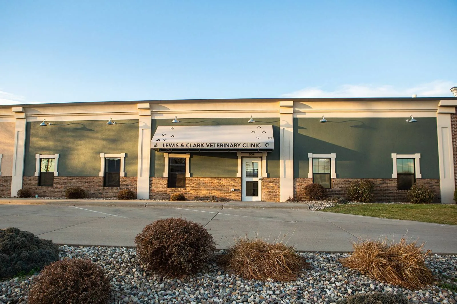 Lewis & Clark Veterinary Clinic exterior in Yankton, SD &mdash; sage-green building with paw-print awning